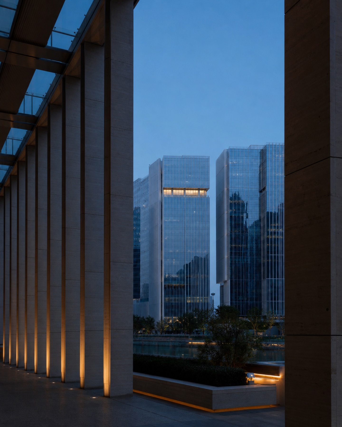 Abu Dhabi financial district viewed through a stone colonnade at blue hour